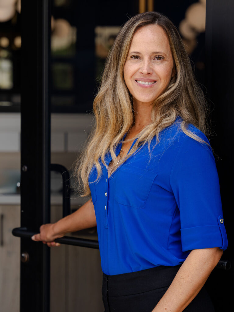 Smiling woman in a blue blouse posing for a commercial branding portrait.