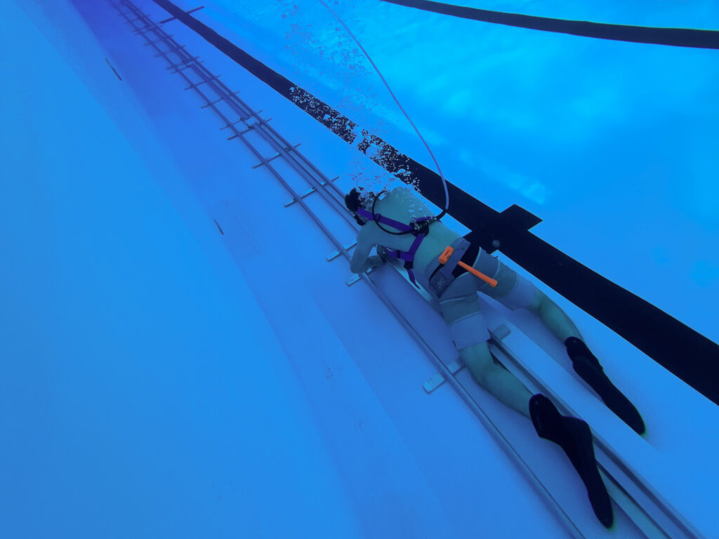 Underwater camera operator beside the 115-foot camera dolly track used for Enhanced Games swimming coverage.