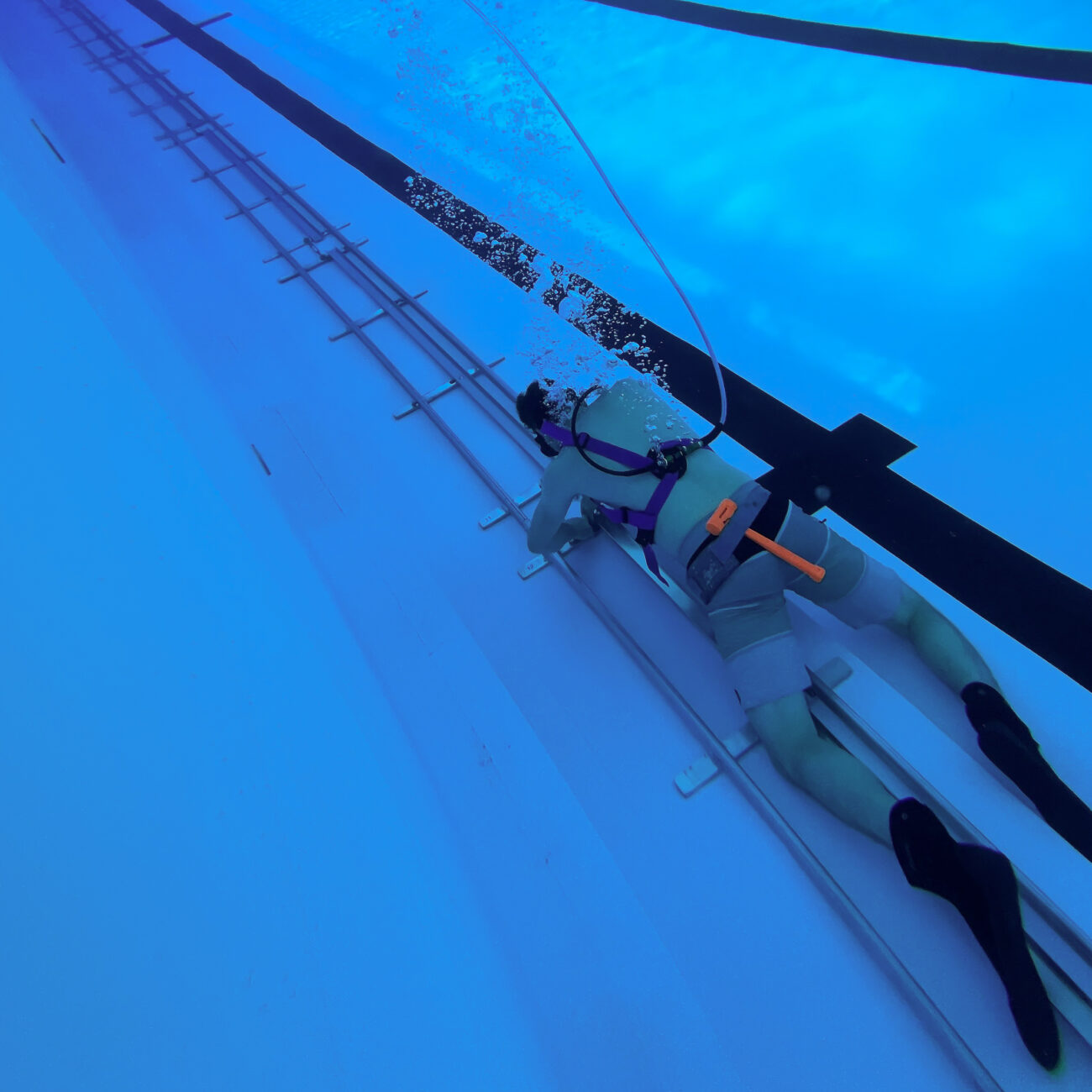 Underwater camera operator beside the 115-foot camera dolly track used for Enhanced Games swimming coverage.