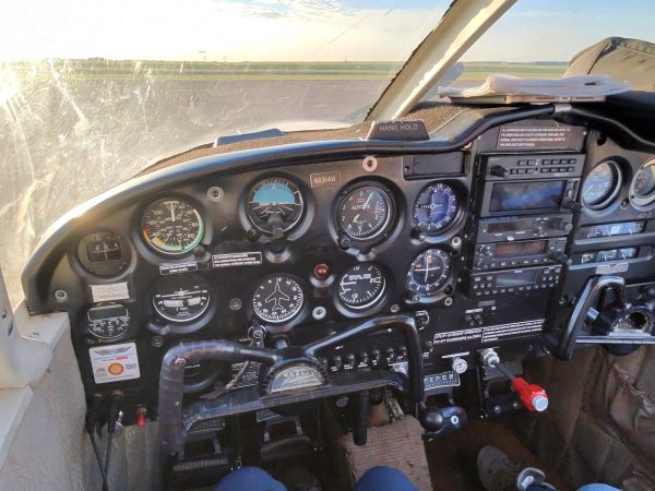 Analog instruments and controls inside a small aircraft cockpit.