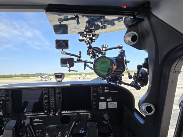 Multiple compact cameras mounted inside an aircraft cockpit for coordinated aviation filming.